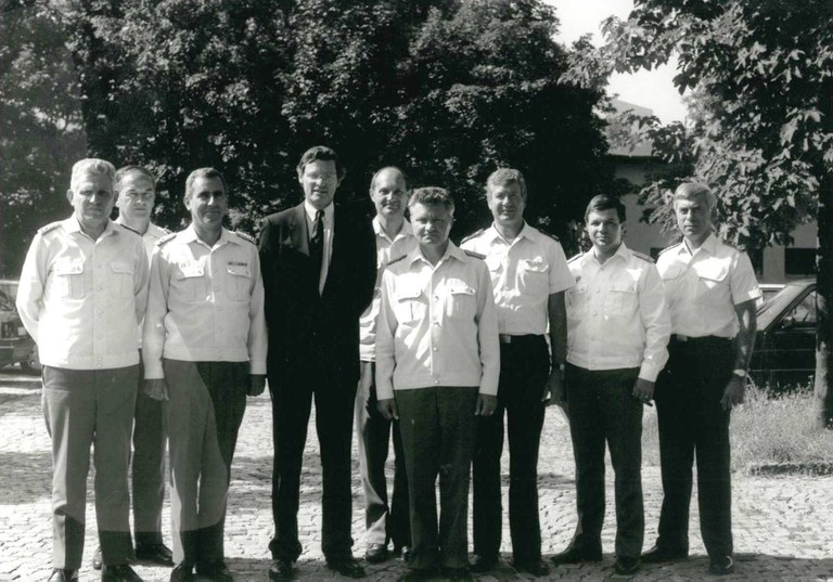 Schwarz-Weiß-Foto: Eine Gruppe von 9 Männer steht auf dem Gelände der Uni. Der vierte von rechts ist Präsident von Krüdener, der einen Anzug trägt, links im Bild stehen drei Männer neben ihm, rechts fünf. Alle tragen dunkle Hosen und helle Oberteile mit Schulterklappen.