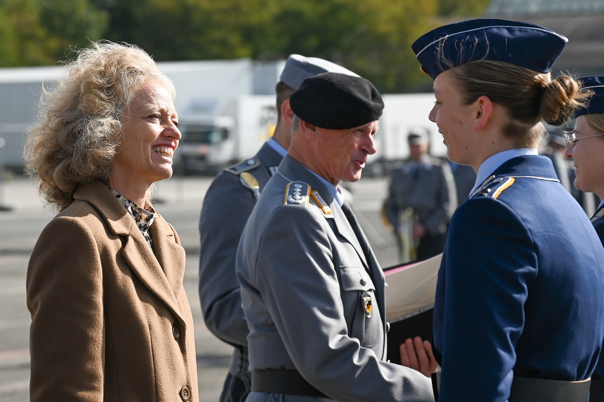 Links im Bild Präsidentin Kern, sie spricht mit einer Soldatin rechts im Bild, die den Dienstanzug der Luftwaffe trägt. Zwischen den beiden ist im Hintergrund Oberst Henkelmann zu sehen, der einer Soldatin gratuliert.