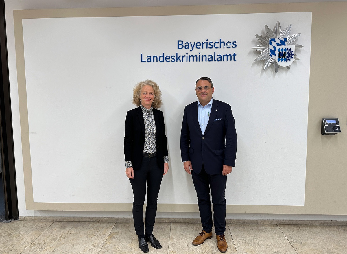 Präsidentin Kern und Präsident Rademacher stehen vor einer Wand, an der das Logo des BLKA zu sehen sind sowie der Schriftzug Bayerisches Landeskriminalamt