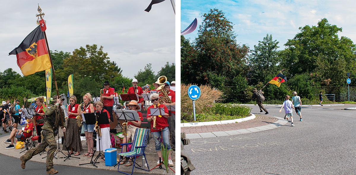 Collage aus zwei Bildern. Links: An einem Kreisverkehr steht eine Band, die verschiedene Blasinstrumente spielt und rote T-Shirts trägt. Im Bildvordergrund rennt ein Soldat, der die deutsche Flagge trägt, vorbei. Rechtes Bild: ein fast leerer Kreisverkehr, durch den der Soldat mit der deutschen Flagge rennt, gefolgt von zwei Kindern, die ihm hinterher rennen. Alle drei sind von hinten zu sehen.